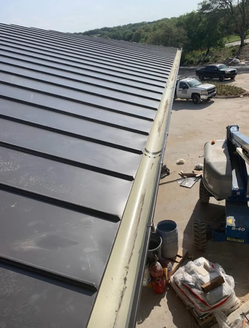 Standing seam panel and gutter detail on a metal roofing jobsite in Lafayette